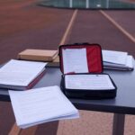 Edifício da CLDF em Brasília com pilhas de documentos simbolizando burocracia em lei sobre primeiros socorros em concursos no DF.