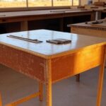 Carteiras escolares em reforma em oficina no DF para ressocialização de reeducandos.