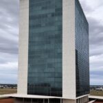 Fachada da Câmara Legislativa do DF em Brasília sob céu nublado, representando aprovação controversa de privilégio para servidores.