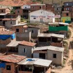 Área de favelas em Brasília contrastando com edifícios governamentais, representando crise habitacional no DF.