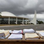 Edifício moderno em Brasília com documentos financeiros, simbolizando reunião sobre suspeitas de irregularidades no BRB e CLDF.