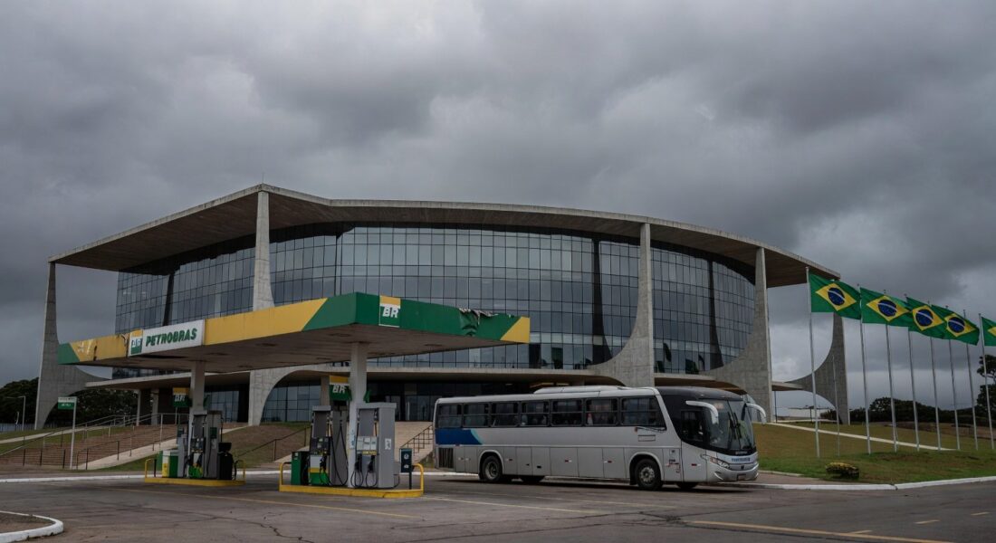 Fachada da Câmara Legislativa do DF com posto de gasolina e ônibus ao fundo, representando aprovação de meia-entrada seletiva e críticas orçamentárias.