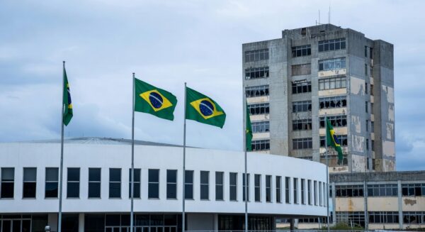 Fachada da CLDF em Brasília com símbolos de crise na saúde do DF, representando críticas em celebração do SindEnfermeiro-DF.