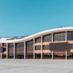 Mesa com documentos de convênio para mestrado em inovação e IA no DF, ao fundo arquitetura de Brasília.