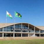 Edifício da Secretaria de Educação no DF, em Brasília, com bandeiras e arquitetura moderna.