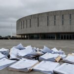 Fachada da Câmara Legislativa do DF com documentos espalhados, expondo falhas na governança do Distrito Federal.