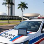 Viatura da PMDF em Brasília com smartphone exibindo app Nexus para agilizar relatórios policiais.