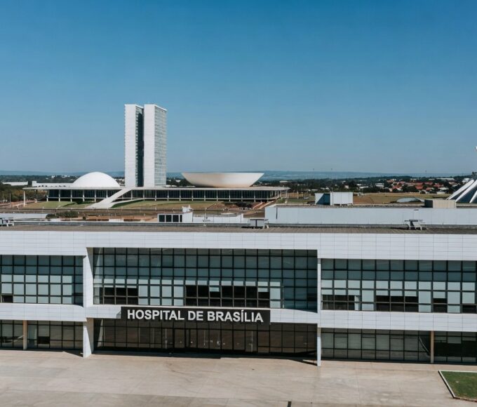 Hospital em Brasília com arquitetura icônica ao fundo, representando redirecionamento de R$ 25 milhões para saúde após cancelamento de comemorações.