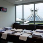 Mesa com documentos financeiros e calendário de prazo vencido, representando perda de prazo do BRB e risco de sanções do Banco Central.