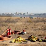 Equipamentos de brigadistas contra incêndios em treinamento no Distrito Federal, com veículos do Ibama e paisagem do cerrado.