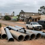 Ligações clandestinas de água em rua de Sucupira, DF, com tubulações improvisadas e mangueiras conectadas ilegalmente.