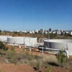 Reservatórios de água inaugurados em Sobradinho, com estruturas modernas e paisagem do Cerrado, anunciando obras para 355 mil moradores.