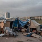 Área urbana em Brasília com barracas improvisadas e pertences de moradores em situação de rua